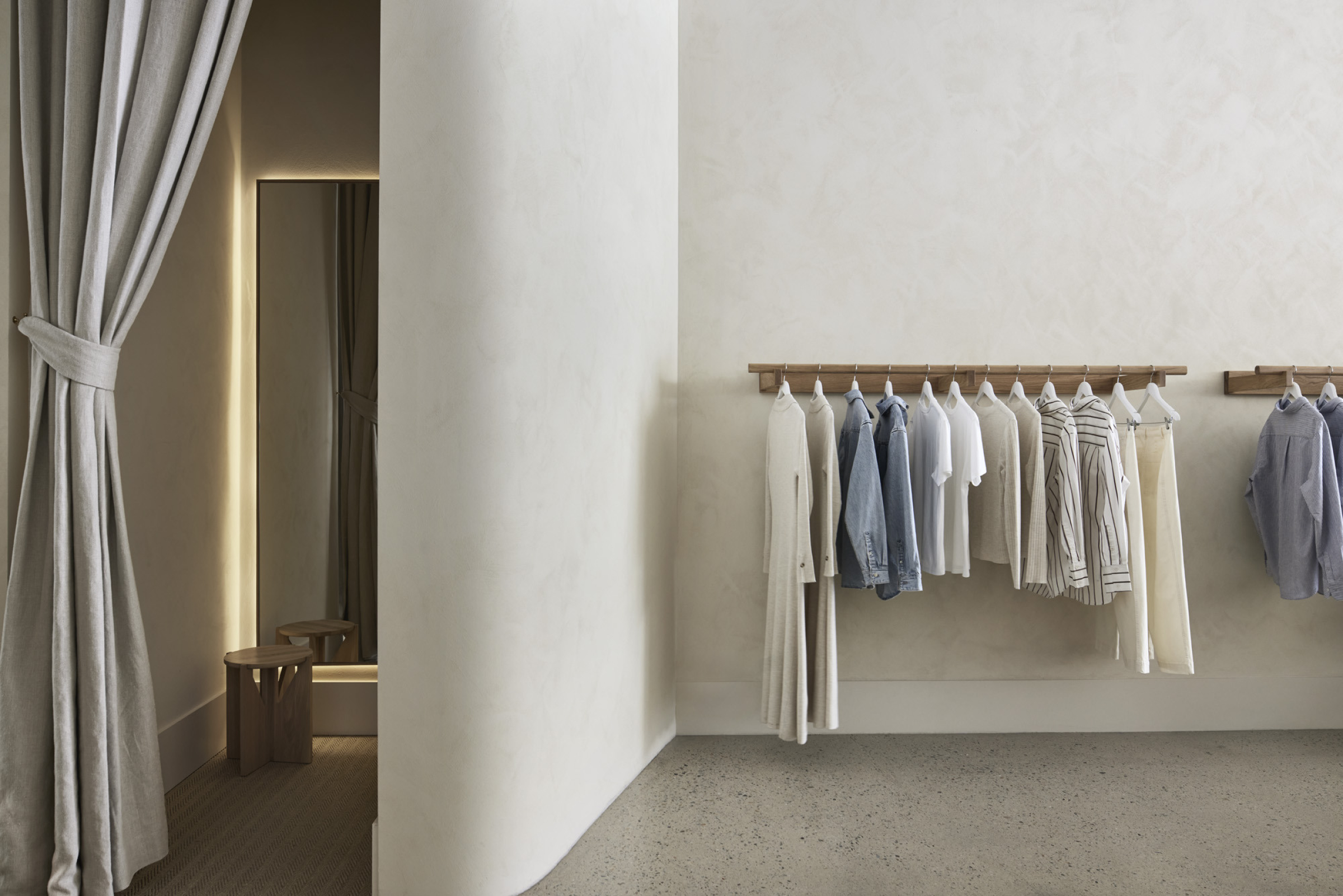 Interior of Assembly Label, Adelaide, showcasing minimalist clothing display and fitting room.