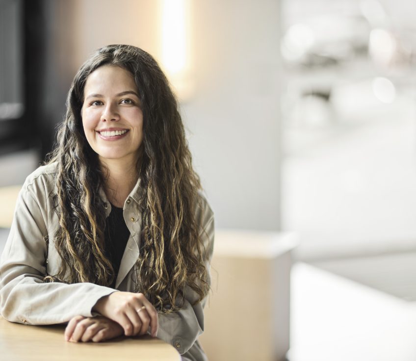 Kmila sitting at a table indoors.