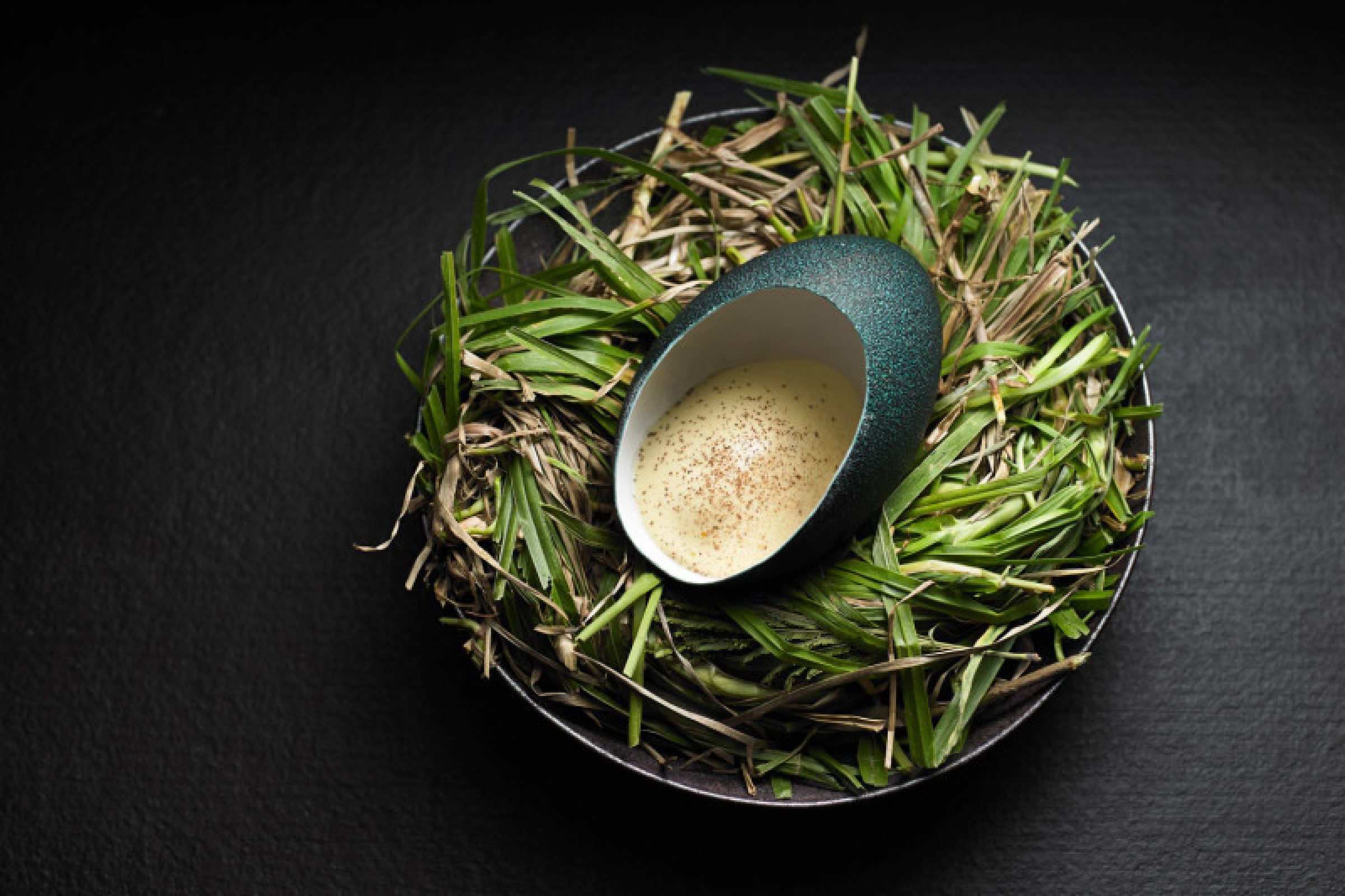 Attica features a ceramic egg with creamy filling nestled in a bed of grass.