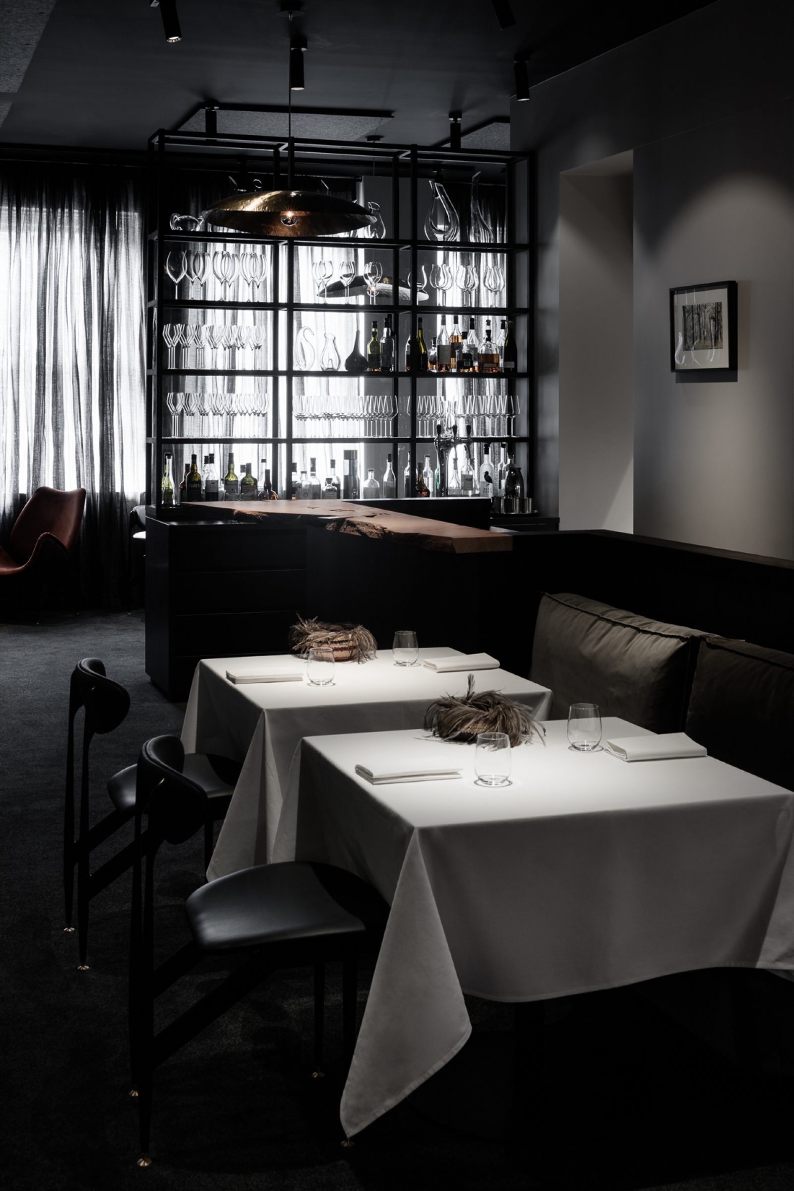 Elegant dining area with white tablecloths and a well-stocked bar in the Attica series.