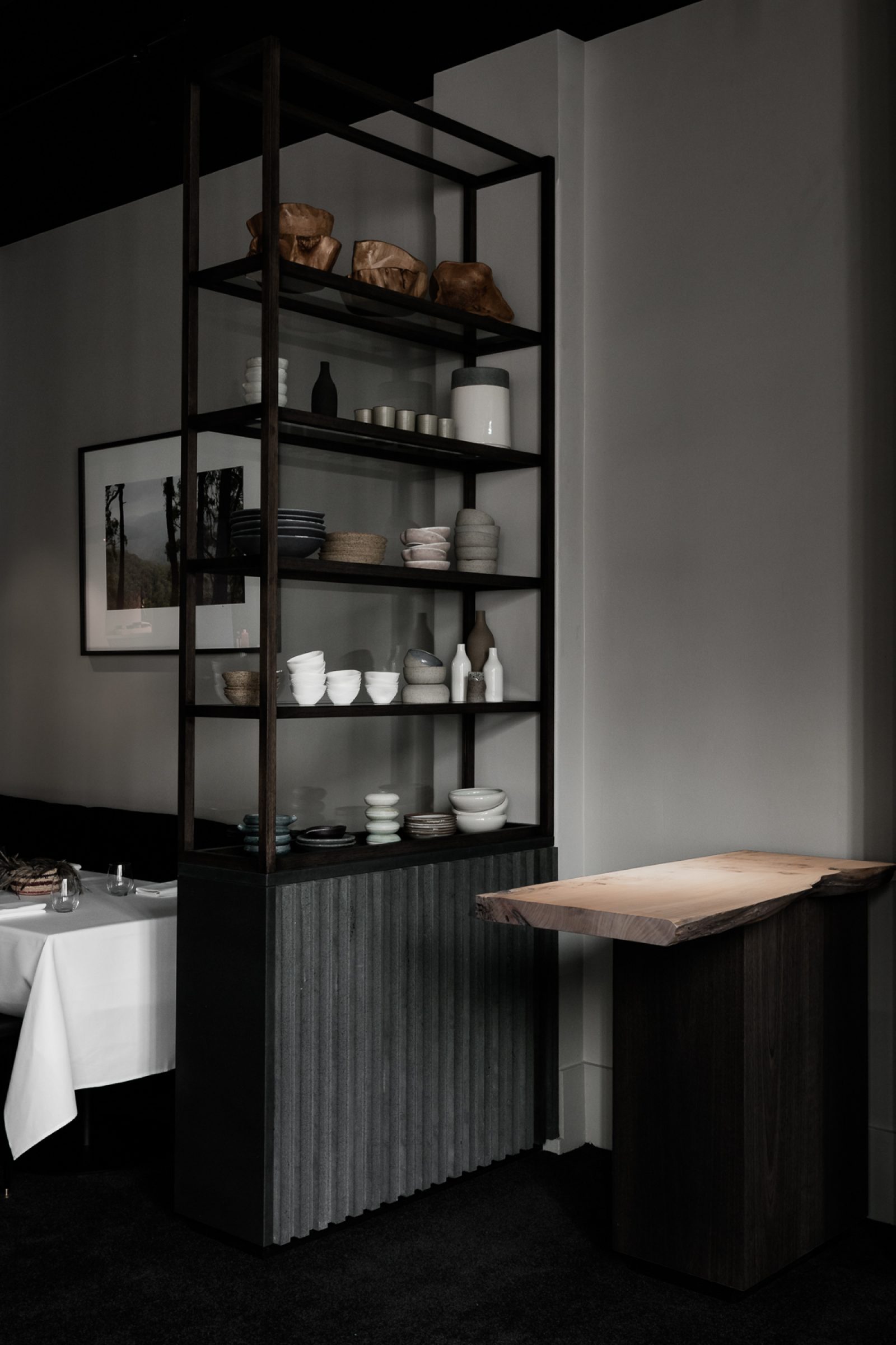 Modern shelving with ceramic dishes in a minimalist dining space for the Attica project.