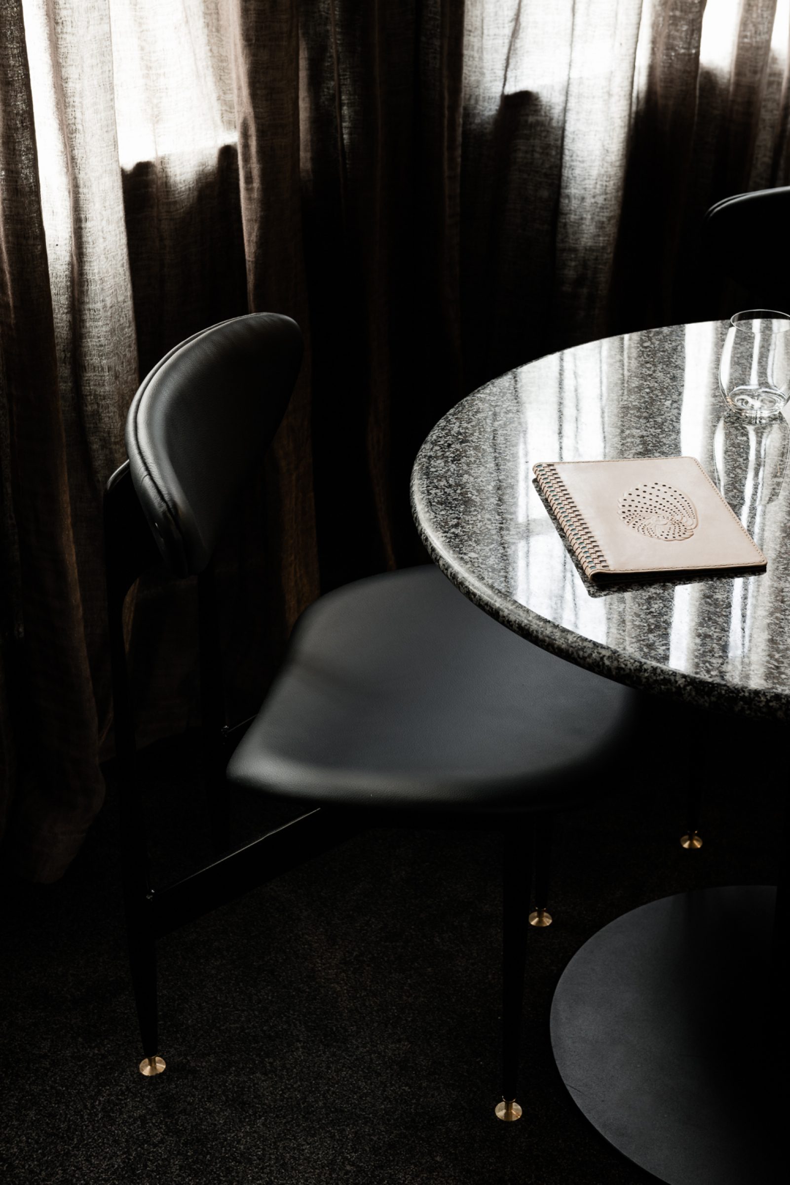 Elegant black chair and round table with notebook from Attica project.
