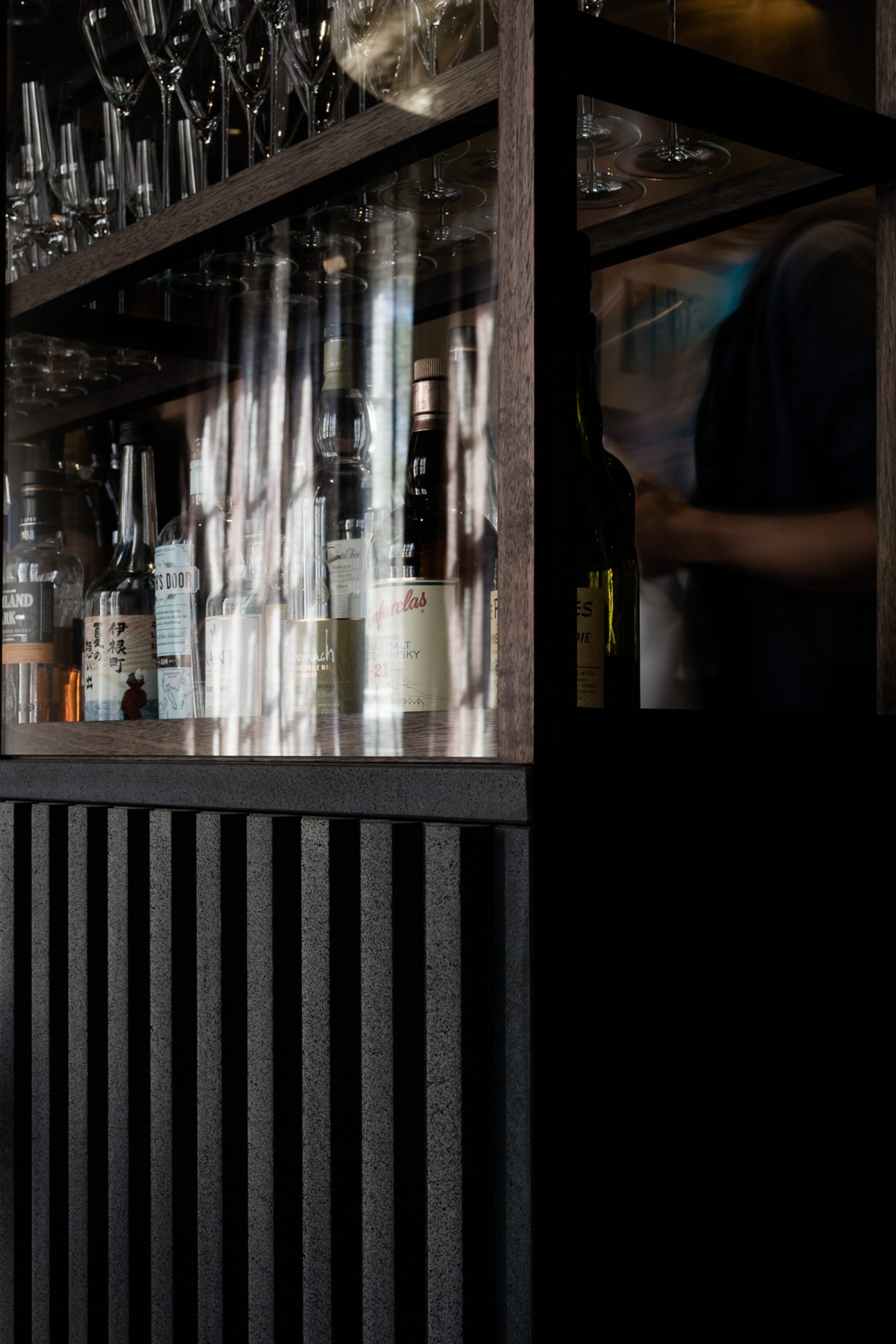 Bar shelf with bottles and glasses in the Attica series.