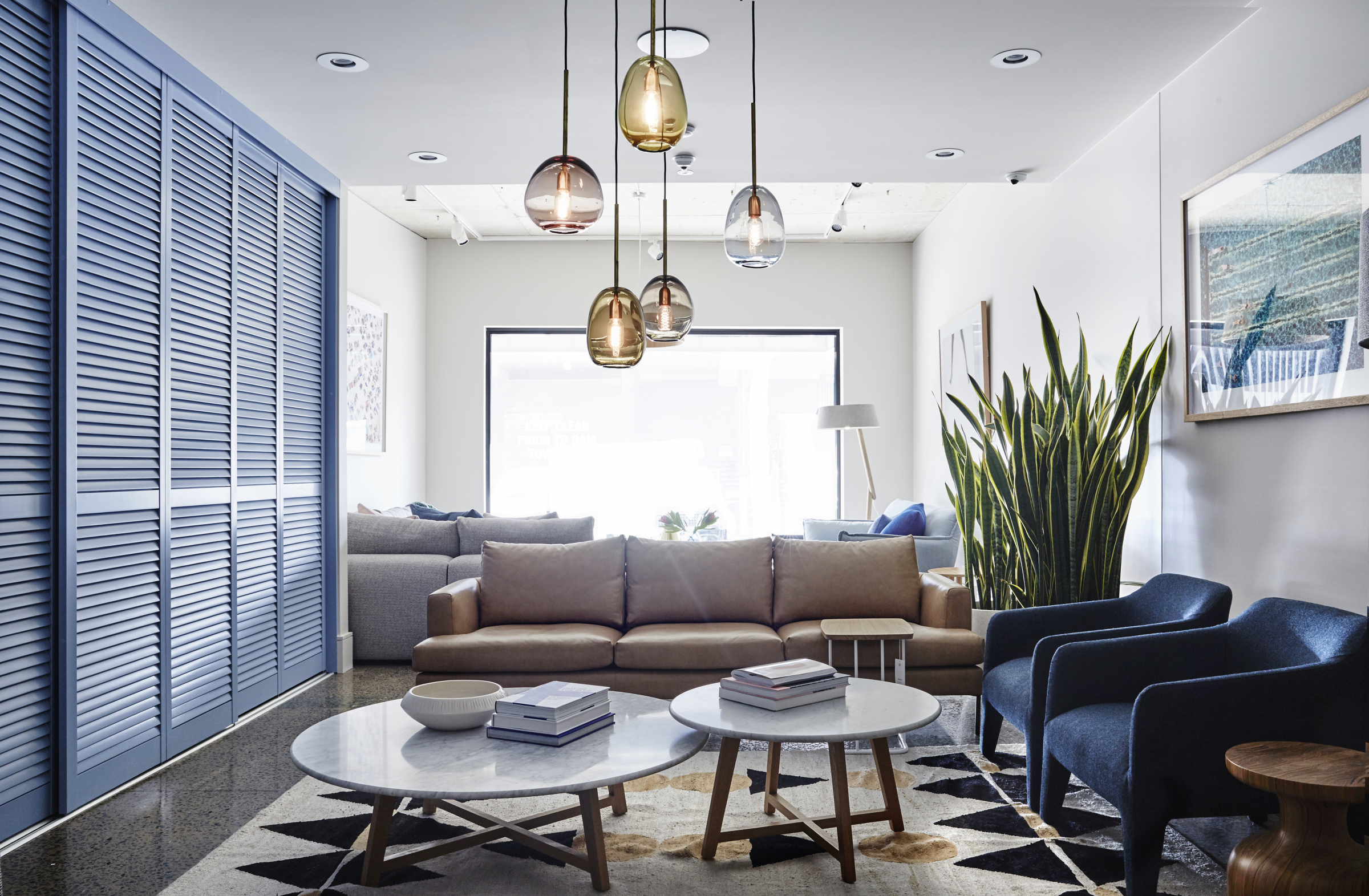 Modern living room interior in Jardan Brisbane with leather sofa and stylish pendant lights.