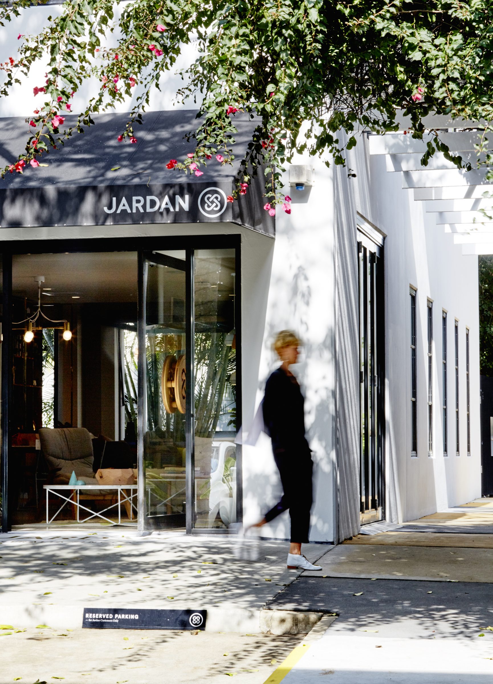Jardan Brisbane storefront with a person walking by and greenery overhead.