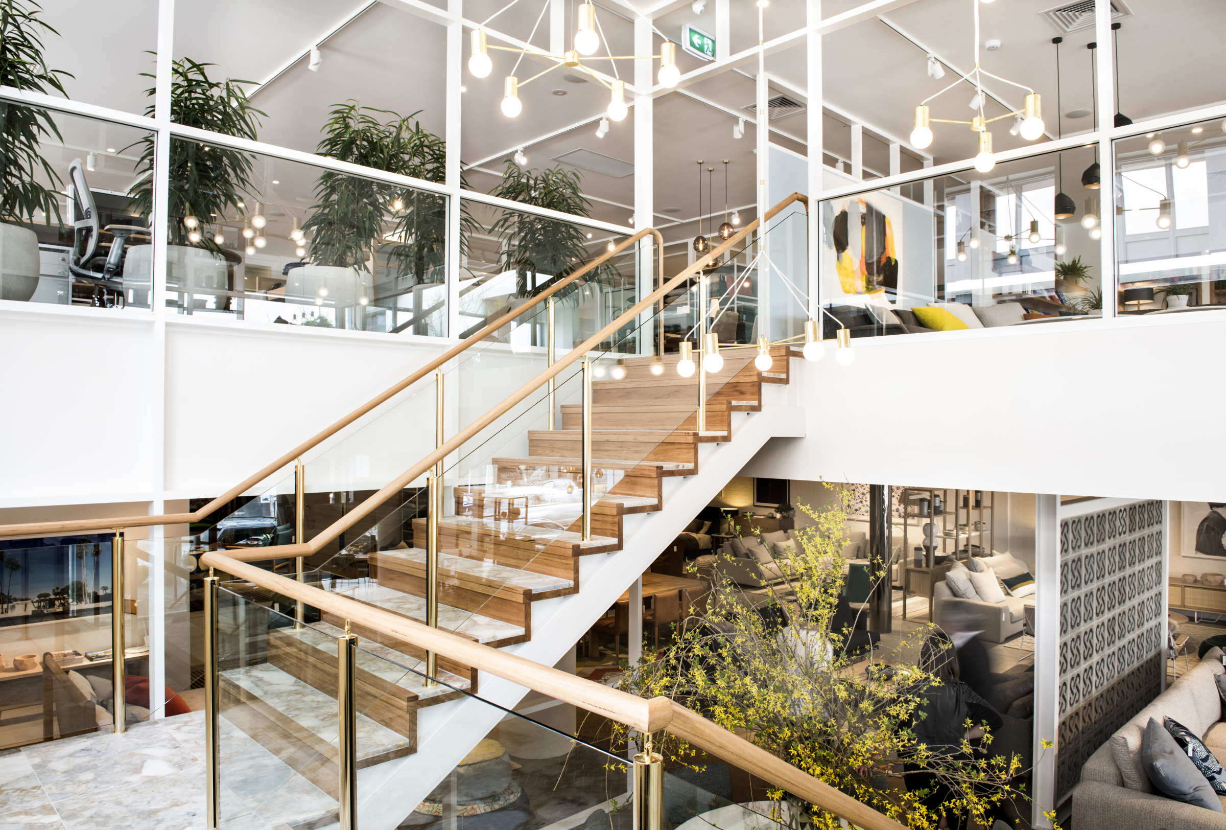 Modern interior design with glass railings and wooden stairs at Jardan Melbourne.