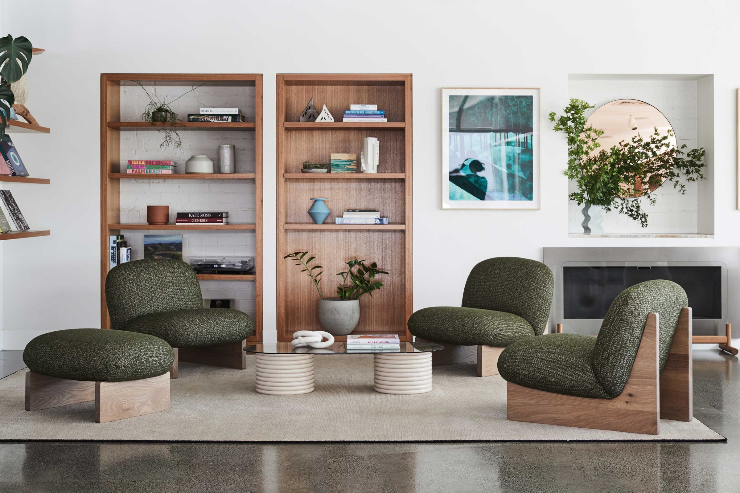 Contemporary living room with green chairs and wooden shelves in Jardan, Melbourne.
