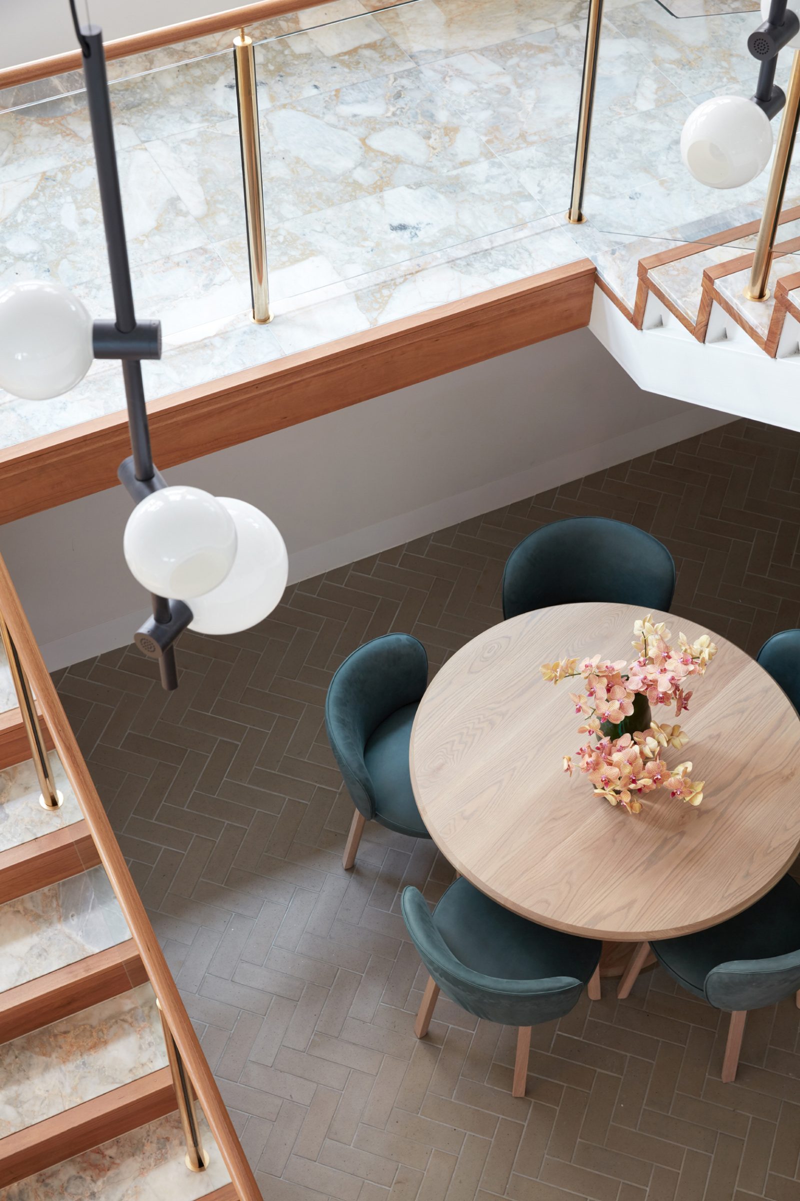 Jardan, Melbourne: Elegant dining area with round table, teal chairs, and floral centerpiece.