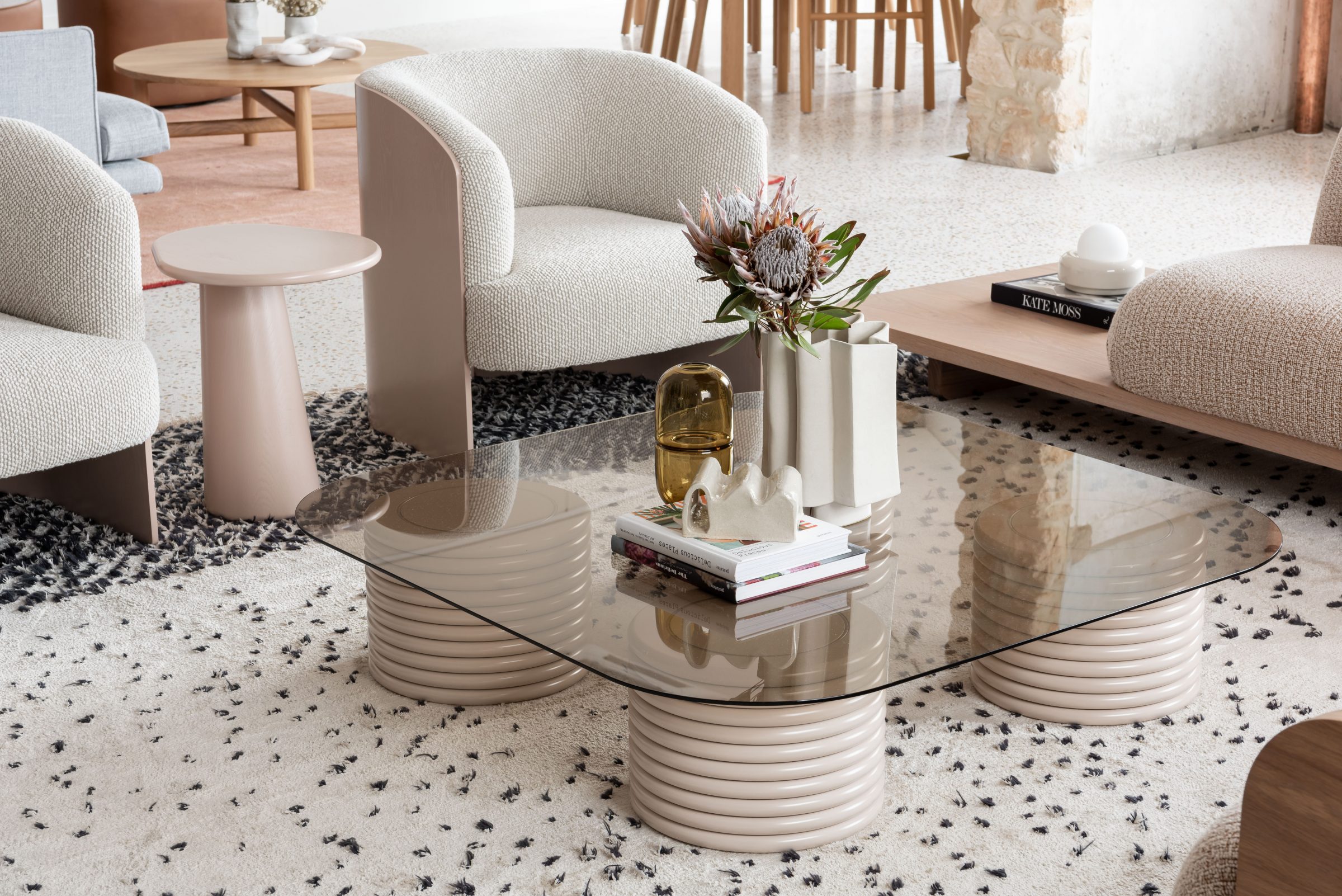Modern living room interior with Jardan furniture featuring a glass coffee table and textured chairs.