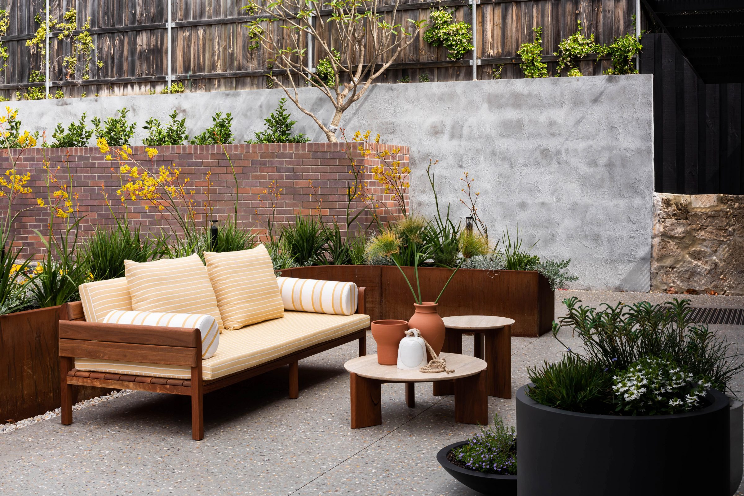 Outdoor seating area with yellow cushions and plants, part of the Jardan design collection.