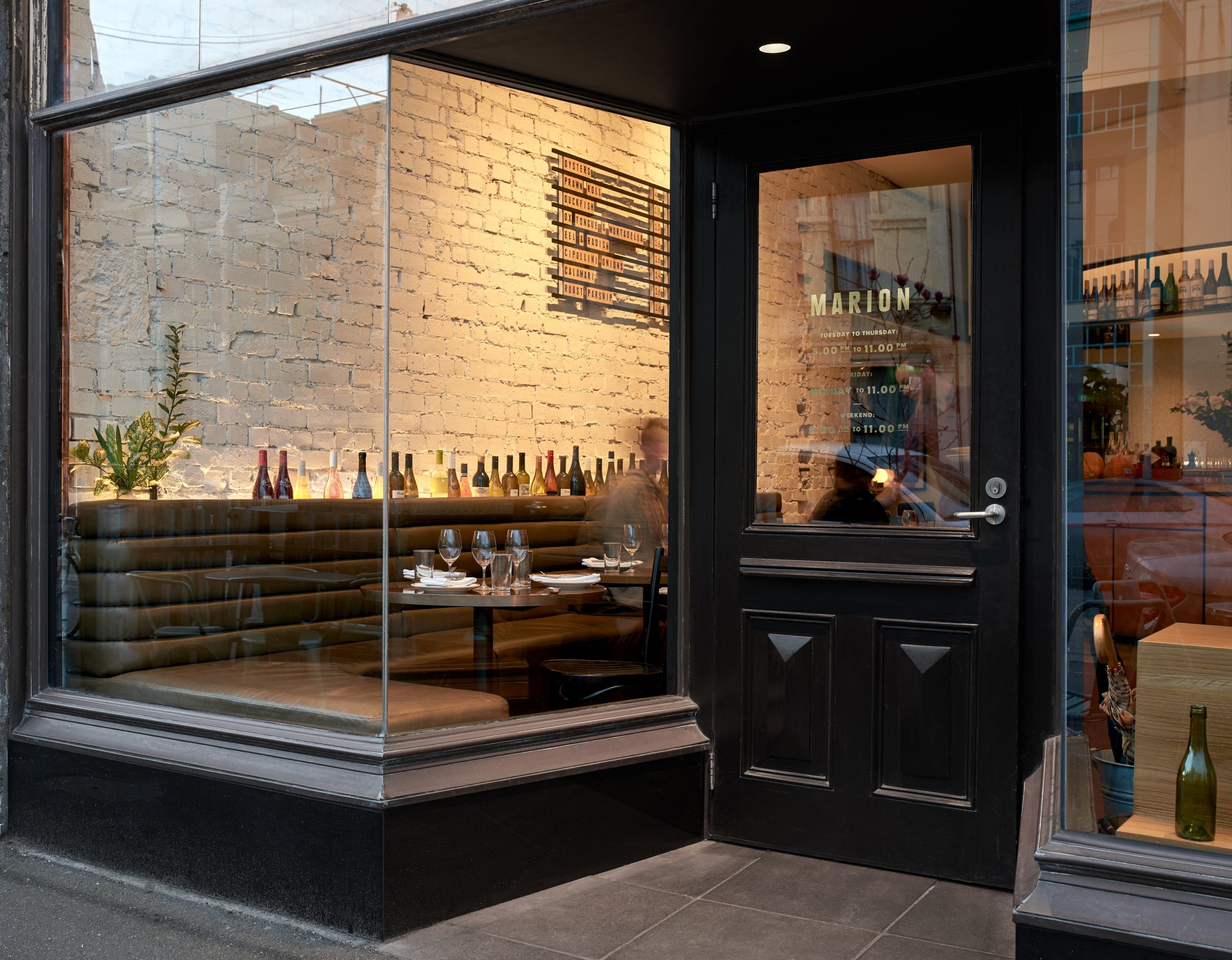 Cozy restaurant interior with a brick wall and wine display, part of the Marion series.