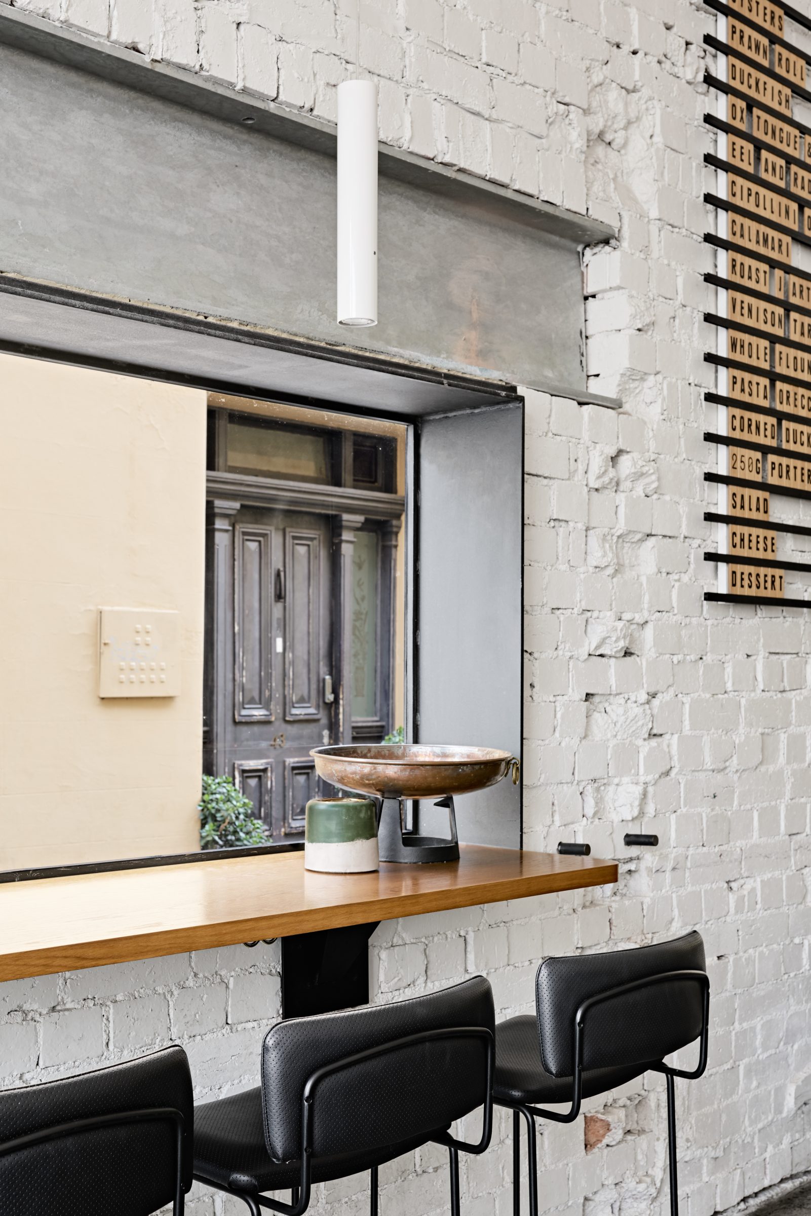 Modern bar seating with a view of a wooden door in Marion interior design.