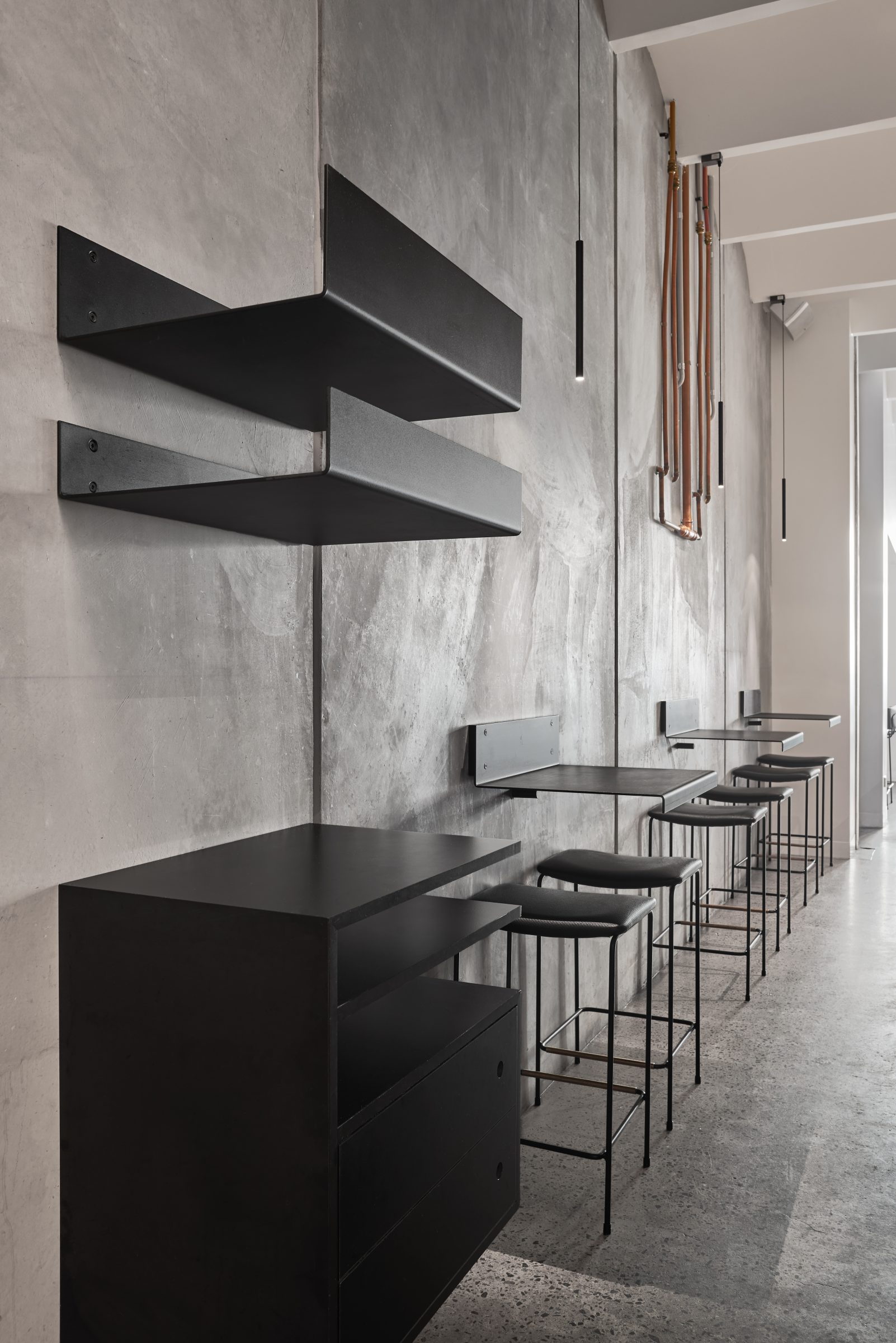 Minimalist interior design featuring black furniture and stools in Marion workspace.