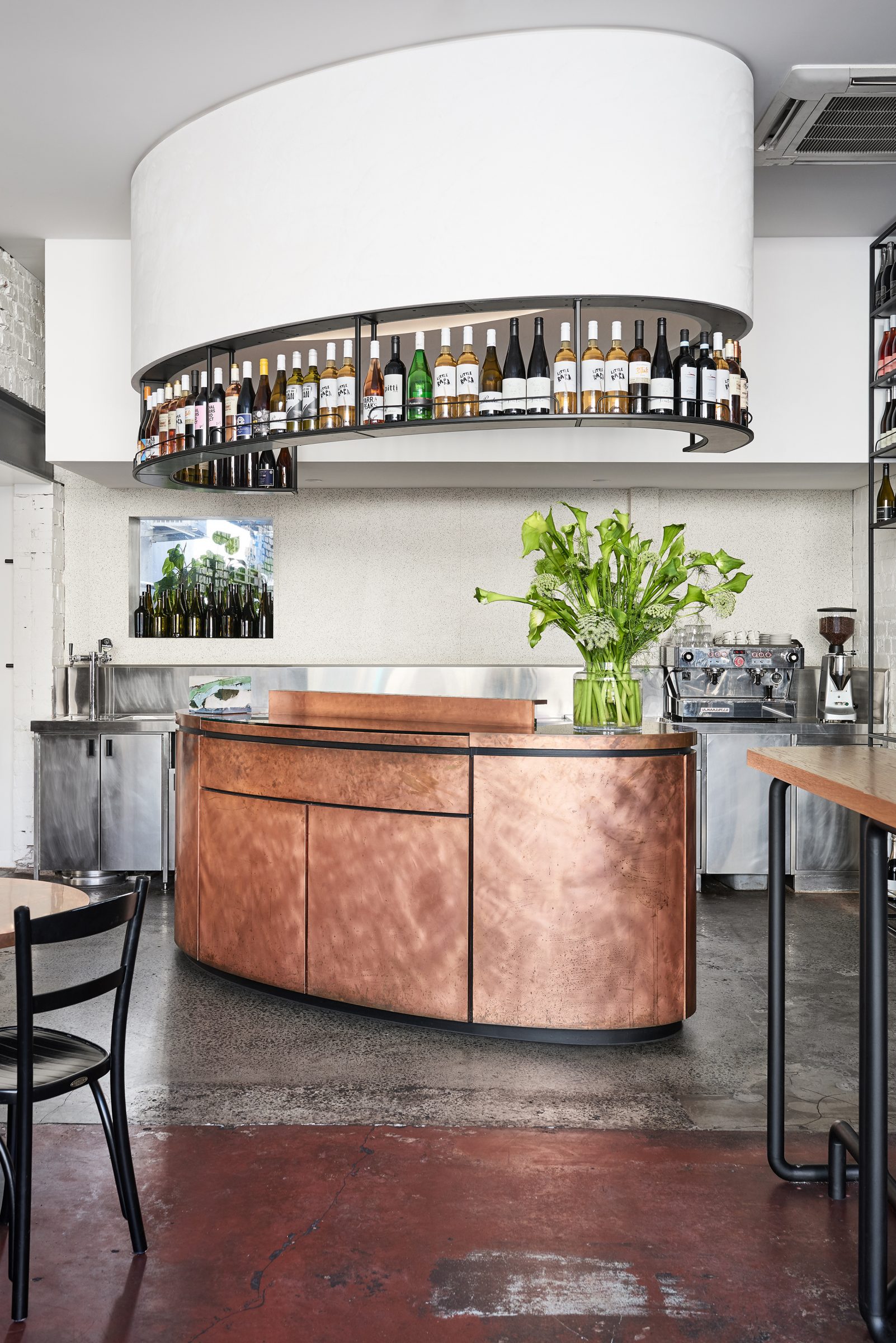 Modern bar interior with copper counter and overhead wine rack in Marion design.