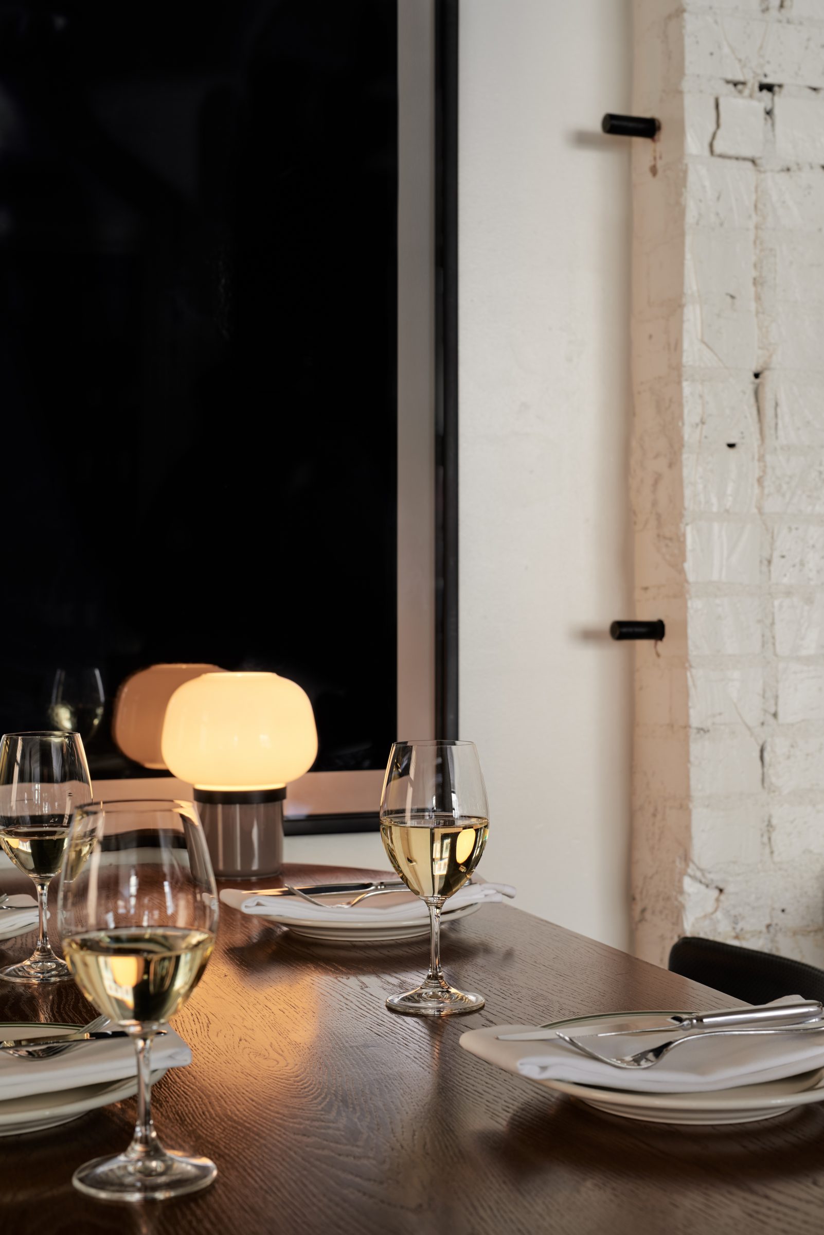 Dining table with wine glasses and soft lighting from Marion.