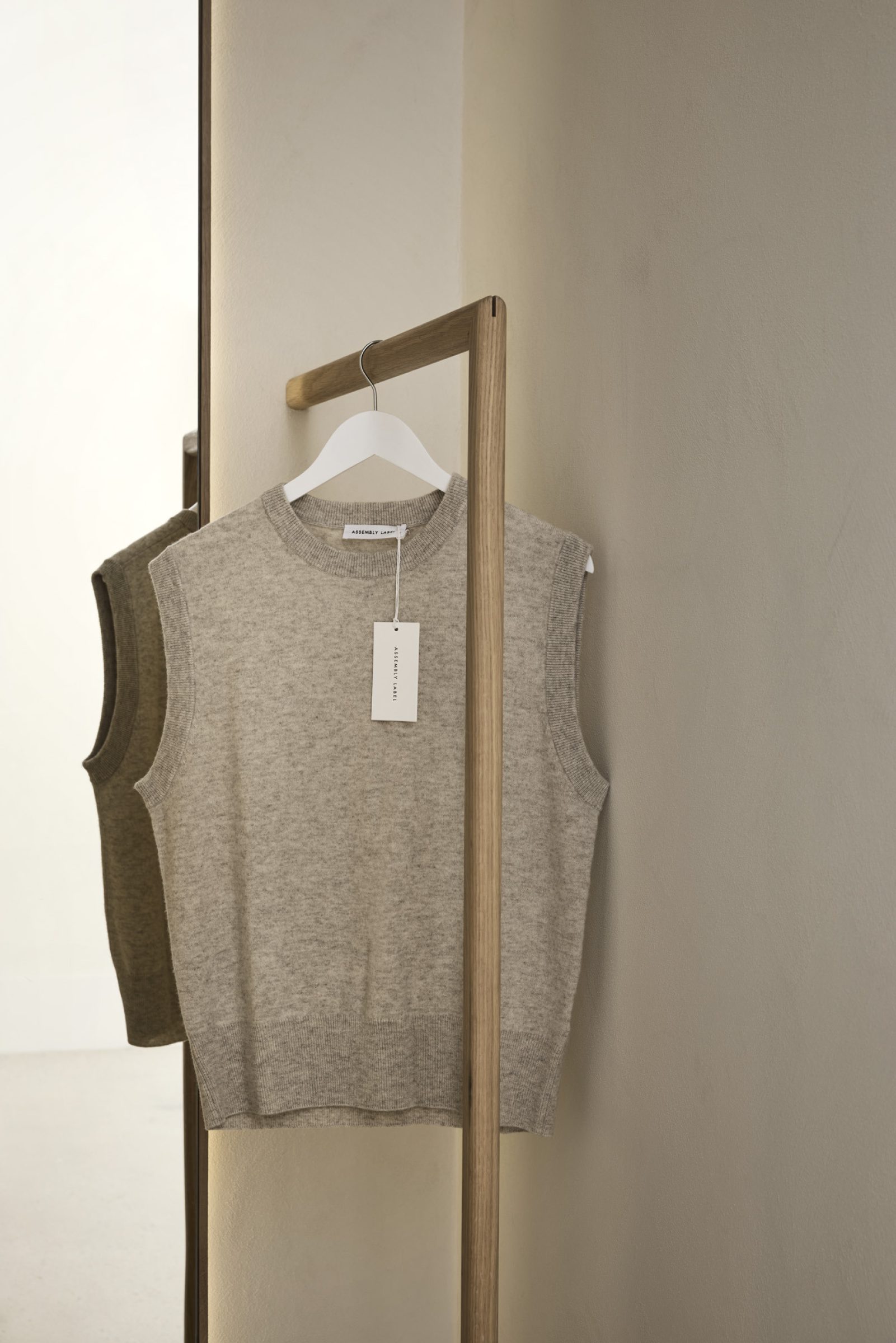 Gray sleeveless sweater on wooden hanger, part of Assembly Label, Adelaide collection.