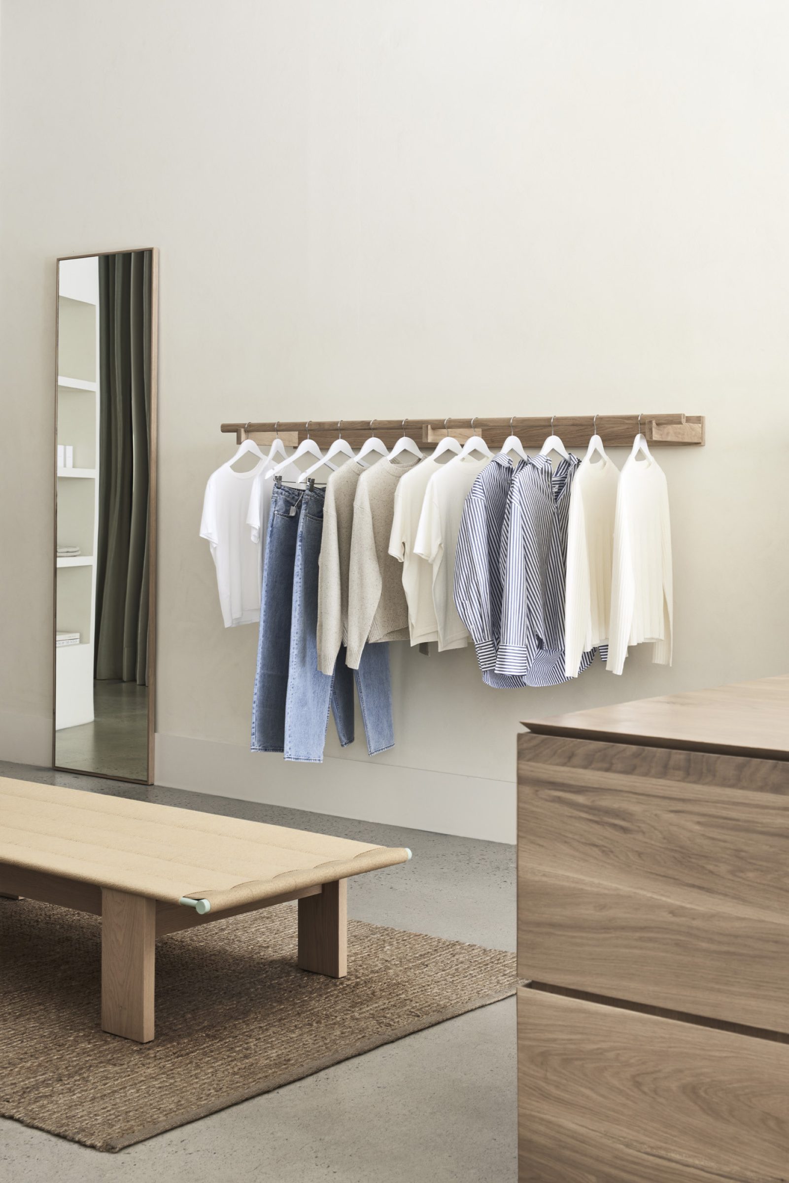 Minimalist clothing display in Assembly Label, Adelaide store with wooden furniture and neutral tones.
