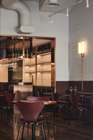 Modern dining area with wine glasses and stylish decor, part of Auterra.