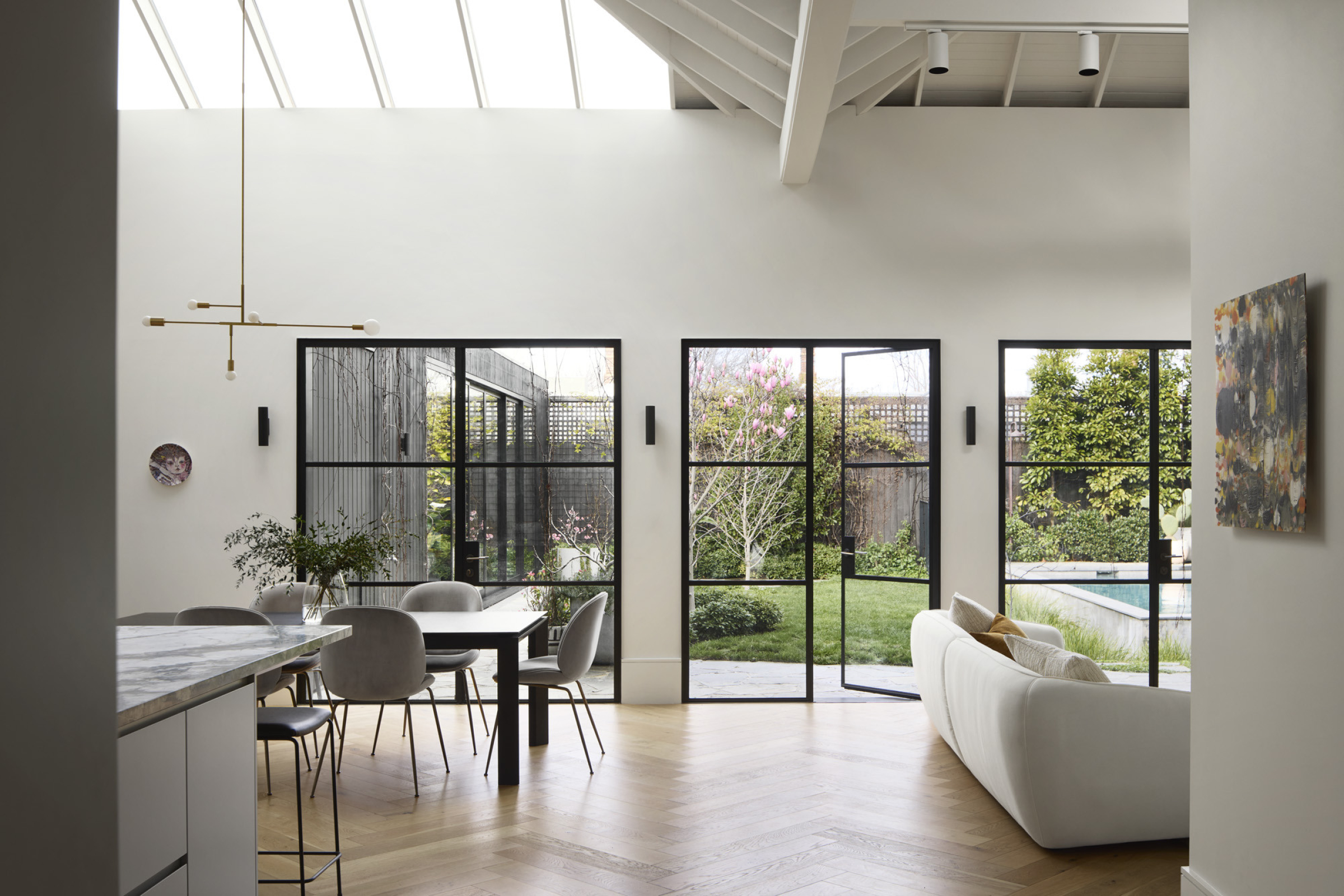 Bright modern interior of Day House with large windows opening to a lush garden.