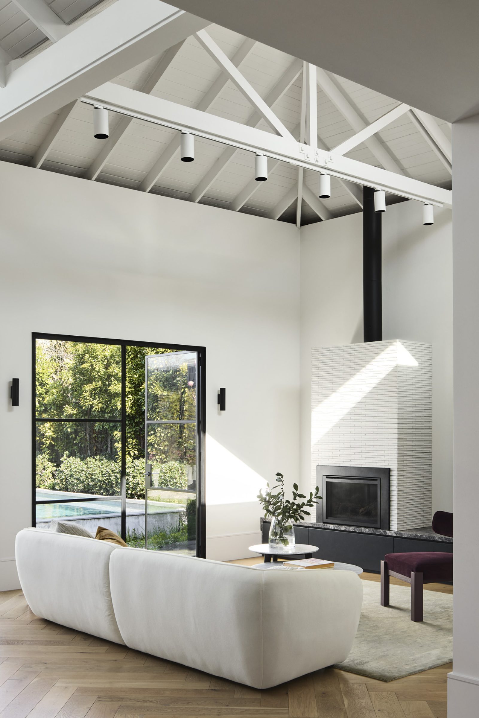 Minimalist living room with high ceilings and large windows in Day House.