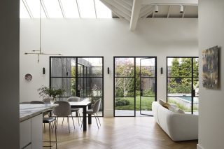 Bright modern interior of Day House with large windows opening to a lush garden.