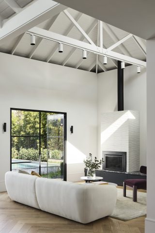 Minimalist living room with high ceilings and large windows in Day House.