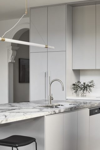 Modern kitchen interior from Day House featuring marble countertops and sleek cabinetry.
