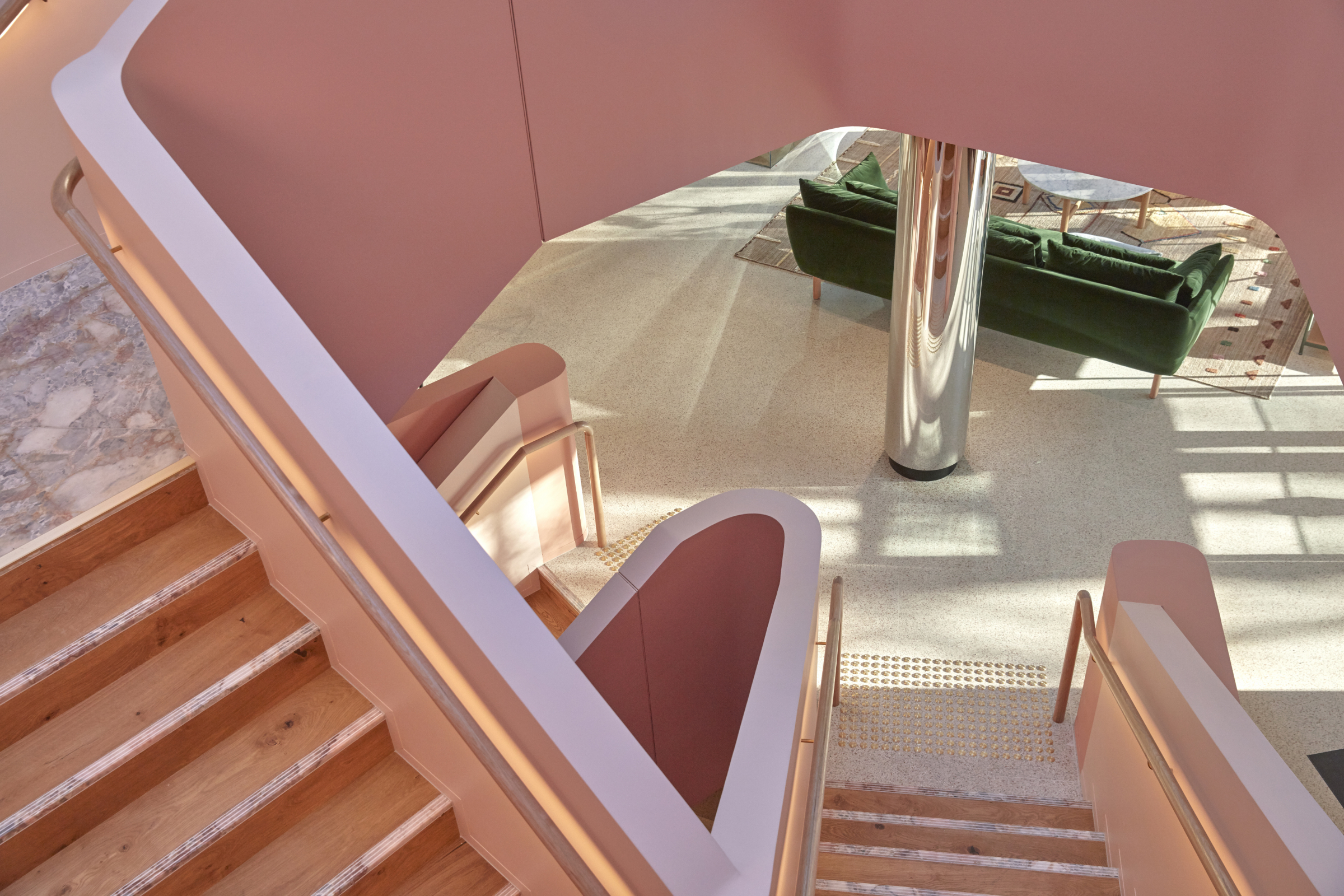 Modern interior design with pink staircase and green sofa in Jardan Sydney.