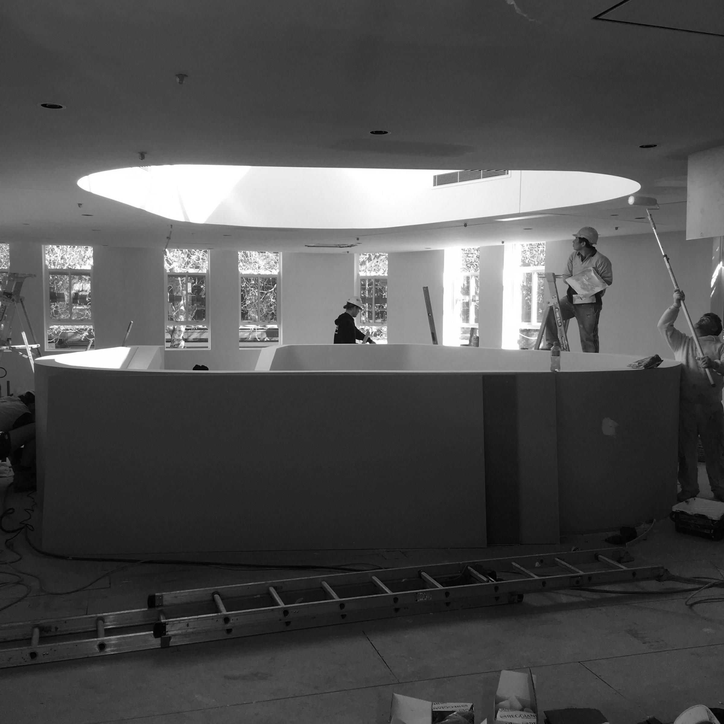Workers inside a modern building under construction for Jardan Sydney with a circular skylight above.