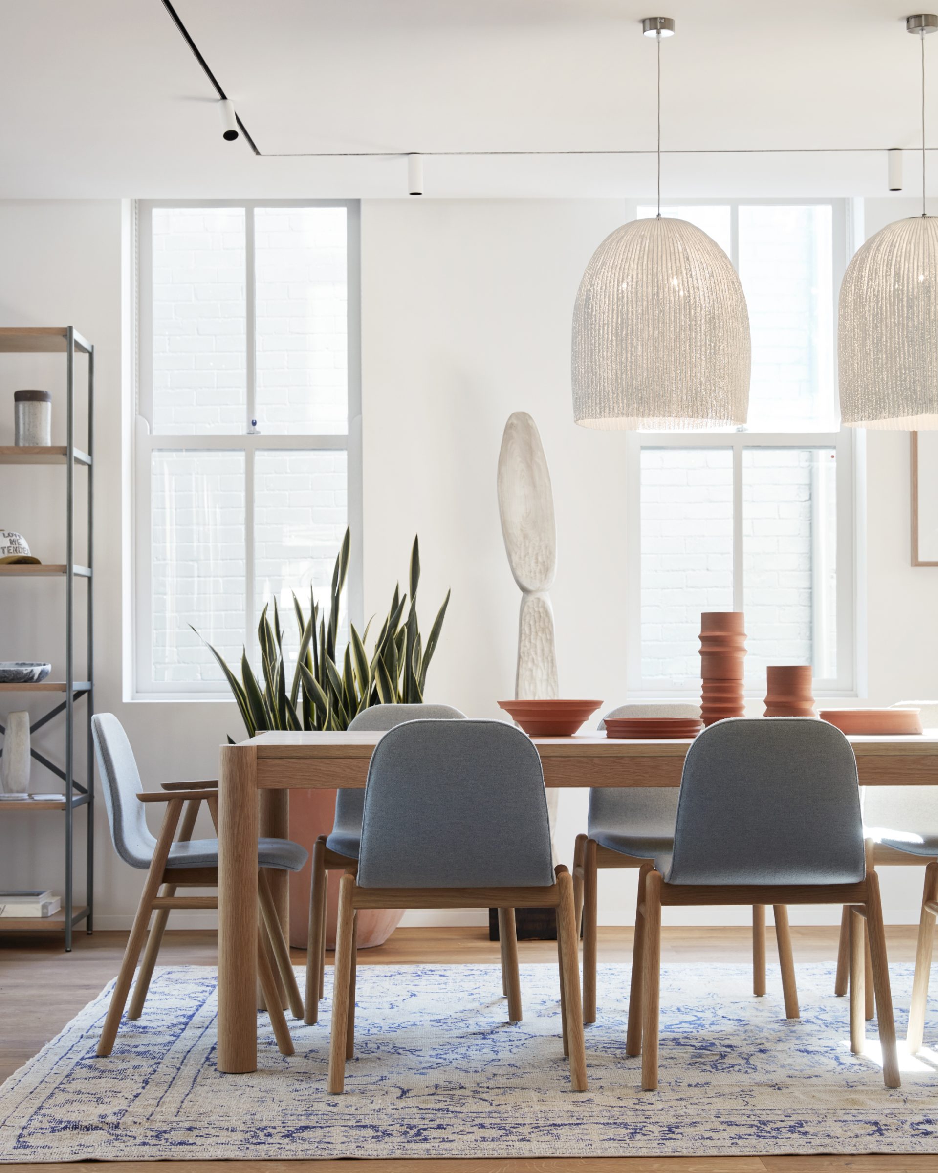 Modern dining room with wooden furniture and large pendant lights in Jardan Sydney setting.