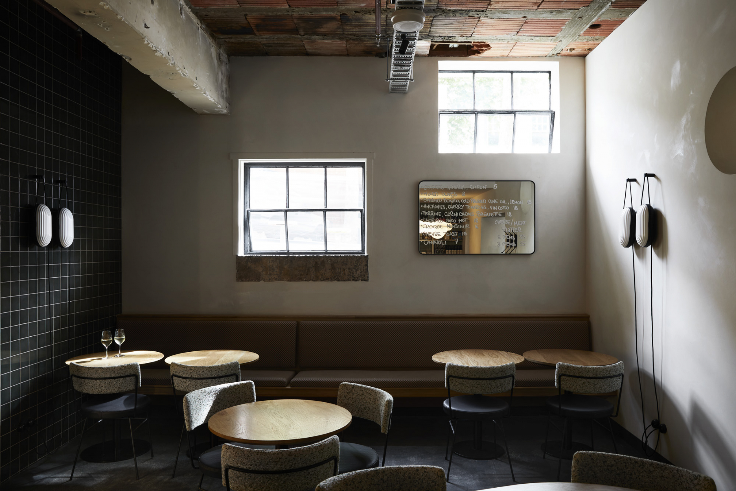 Cozy wine bar interior with round tables and soft lighting from Little Prince Wine.