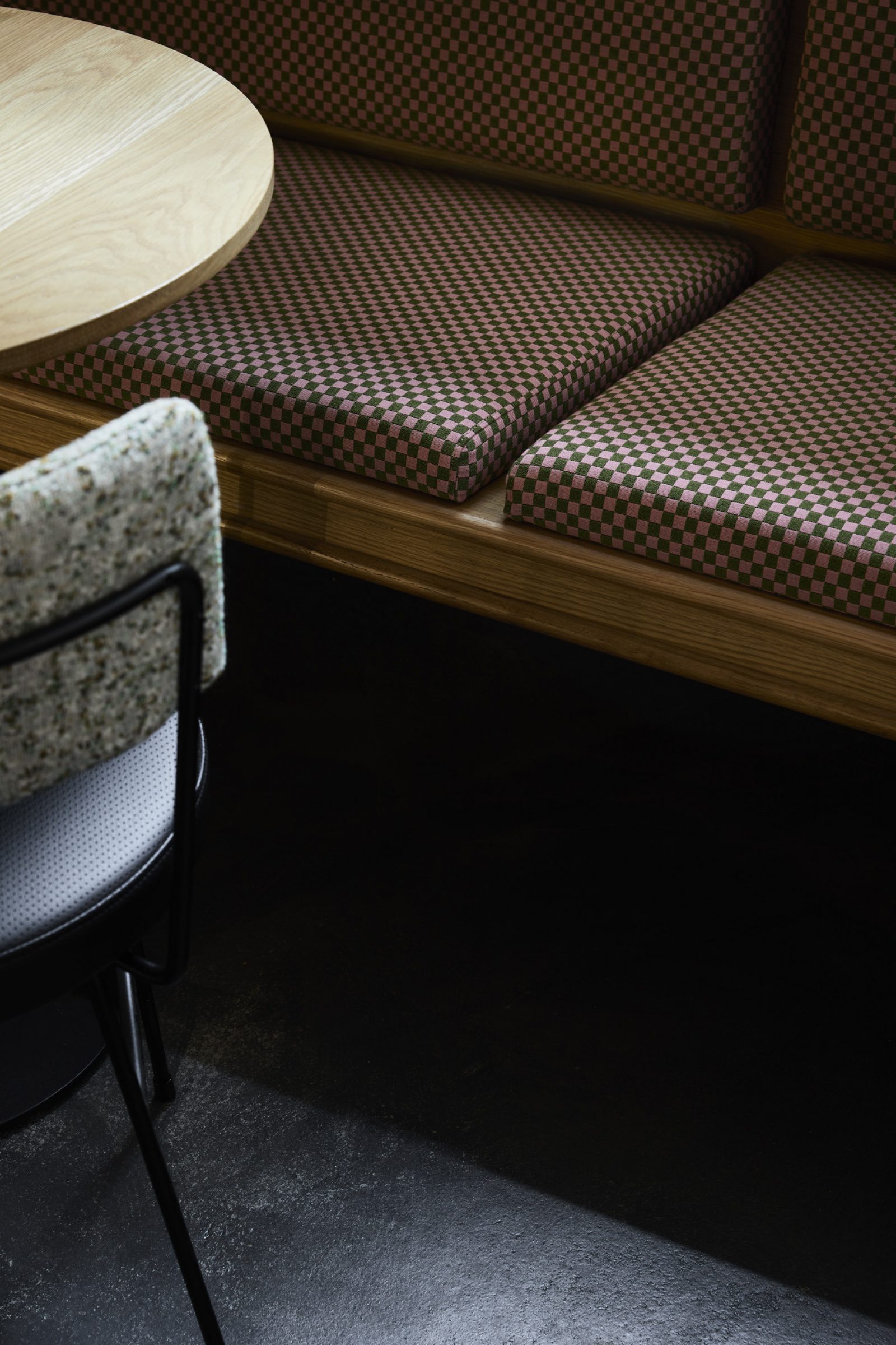 Little Prince Wine seating area with checkered cushions and a wooden table.