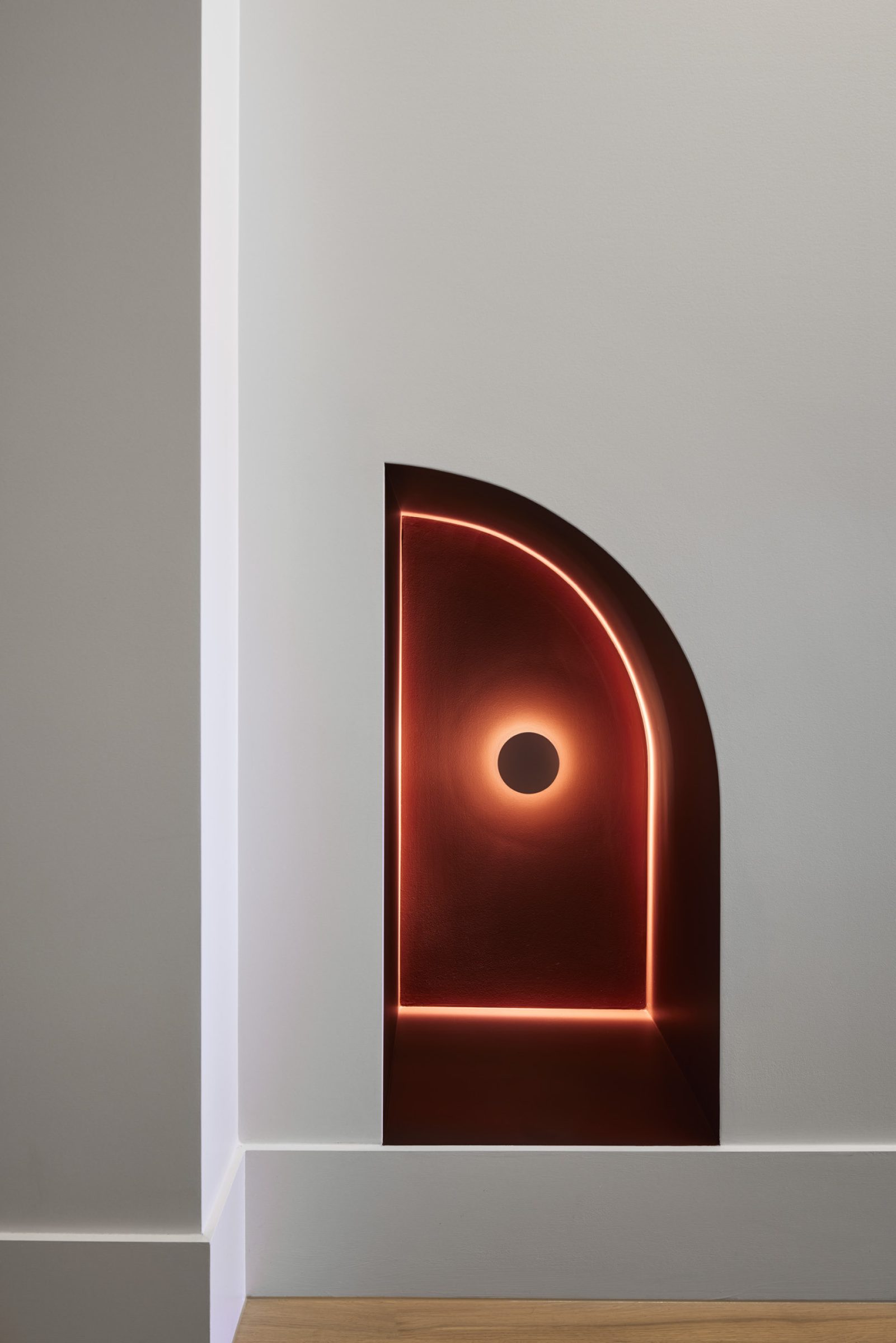 "Lux-Fx features a modern, minimalist wall niche with glowing red lighting accents."