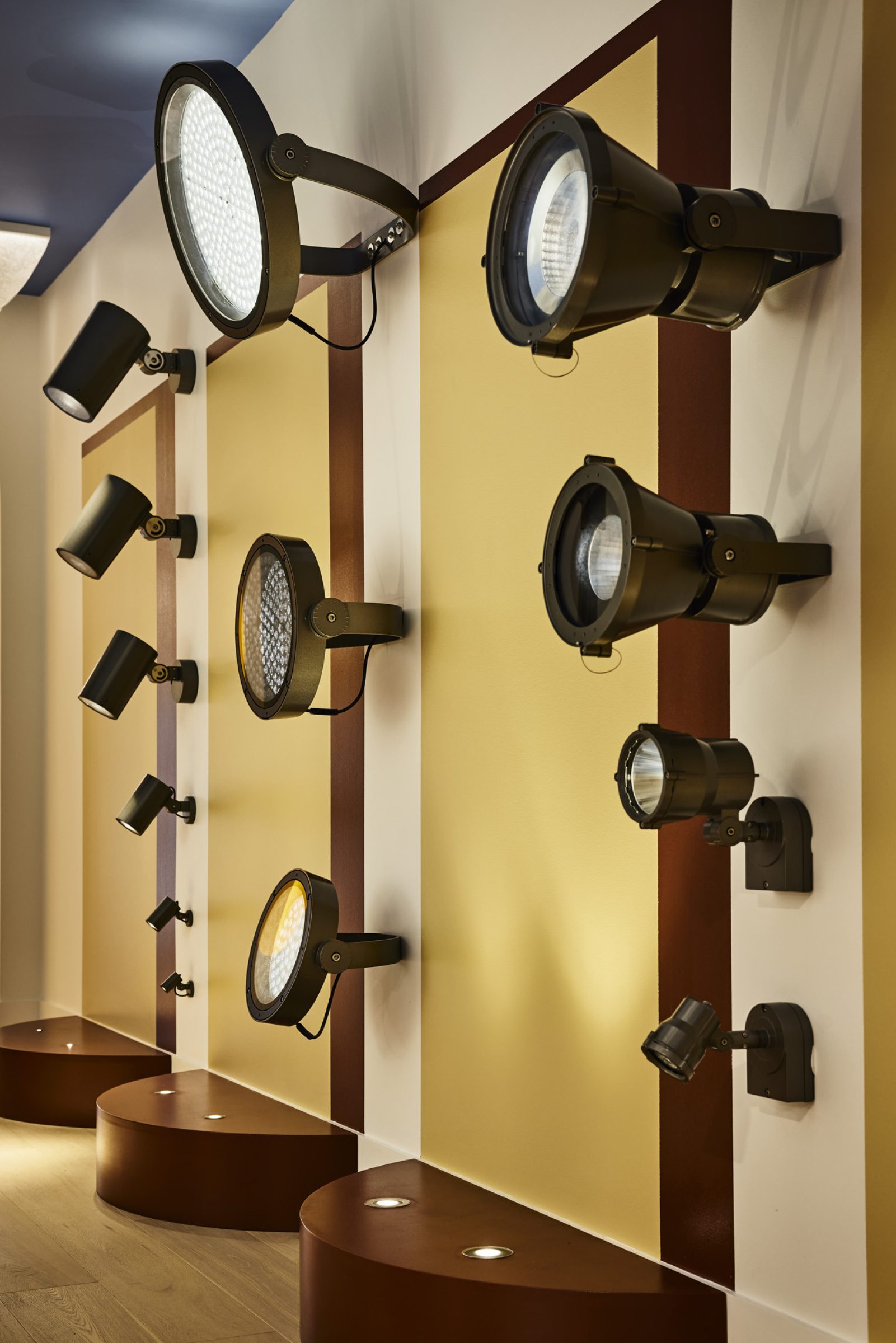 "Lux-Fx showcases a variety of modern wall-mounted lighting fixtures on a stylish display."