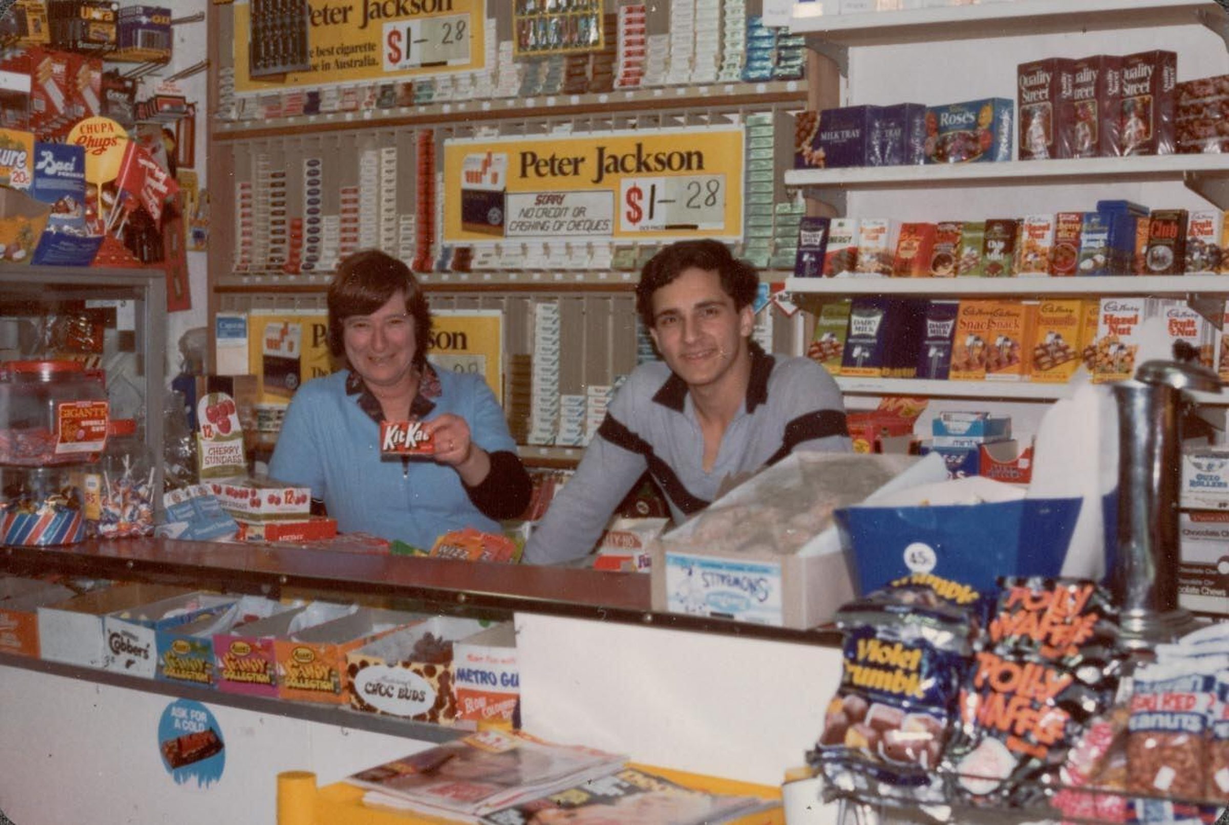 Two people smiling behind a candy shop counter for "Madeleine de Proust" project.