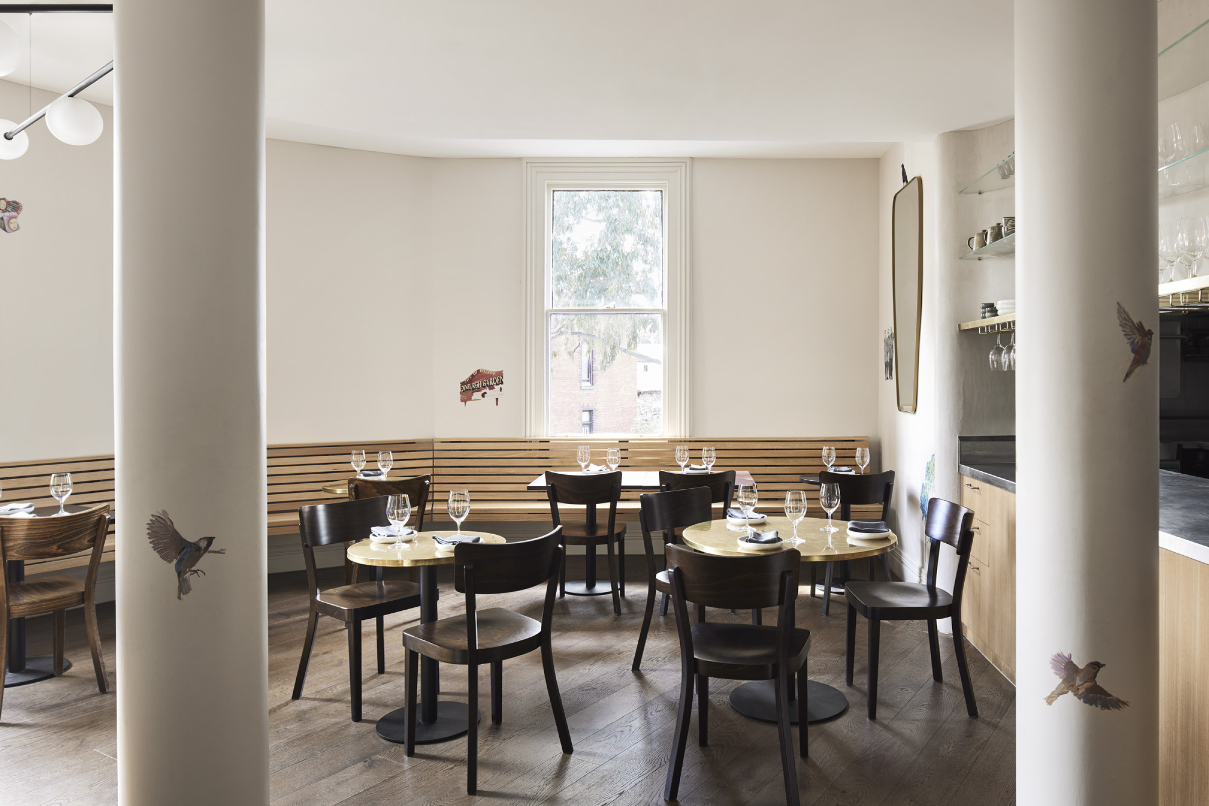 Modern dining area with wooden chairs and tables, part of "One Trick Pony".