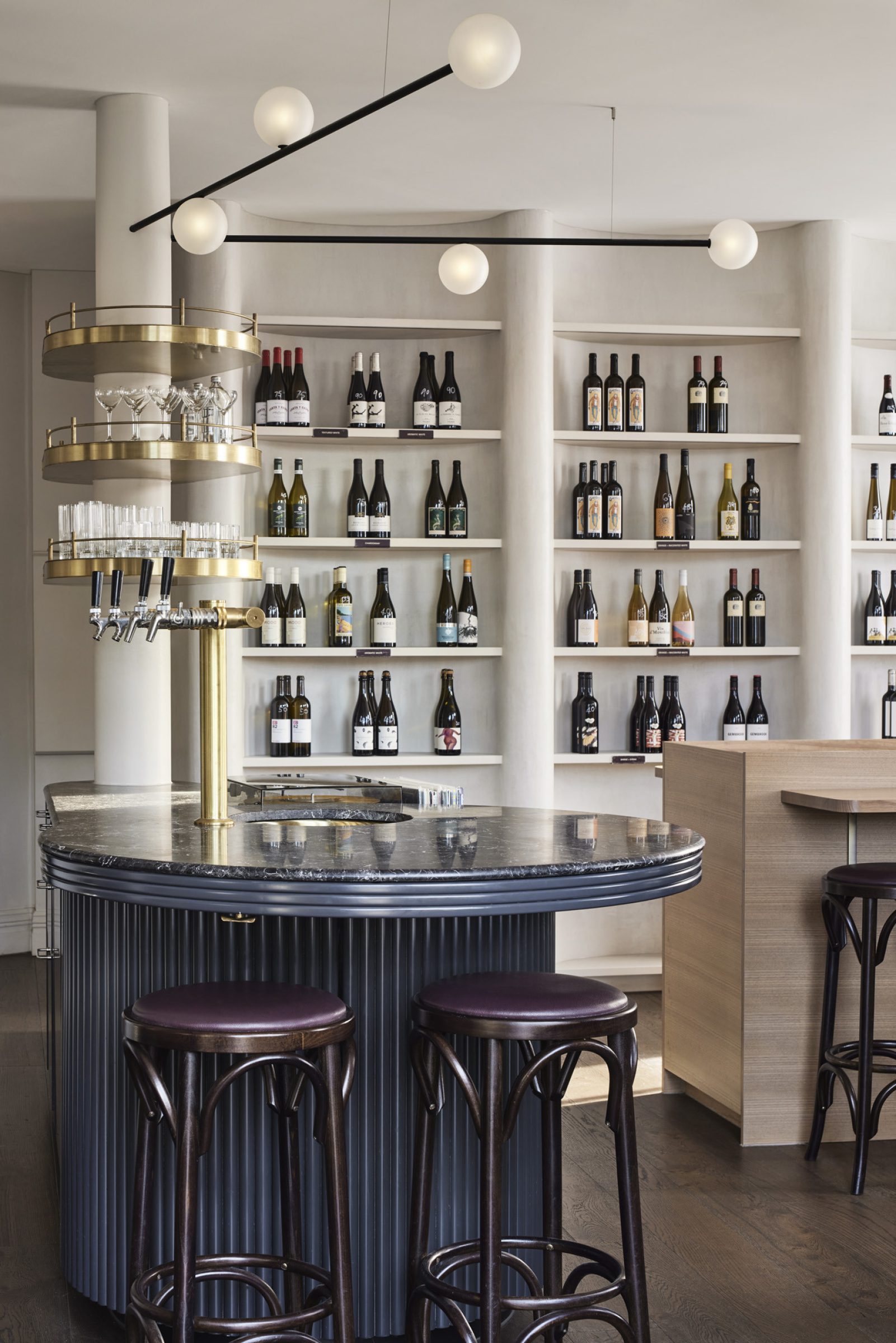 Modern bar interior with shelves of wine bottles, part of "One Trick Pony".