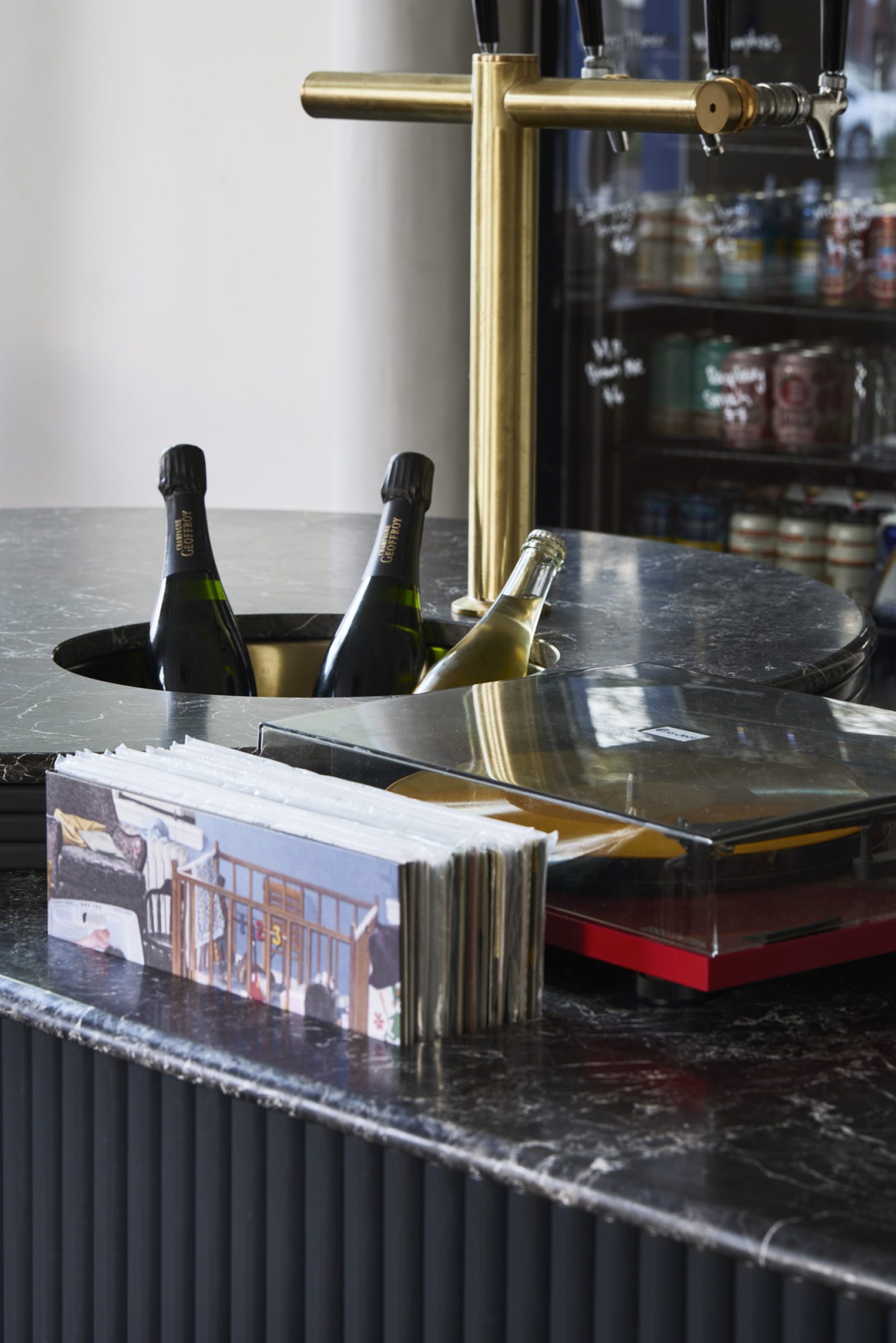 "One Trick Pony features a stylish bar setup with champagne bottles and a turntable."