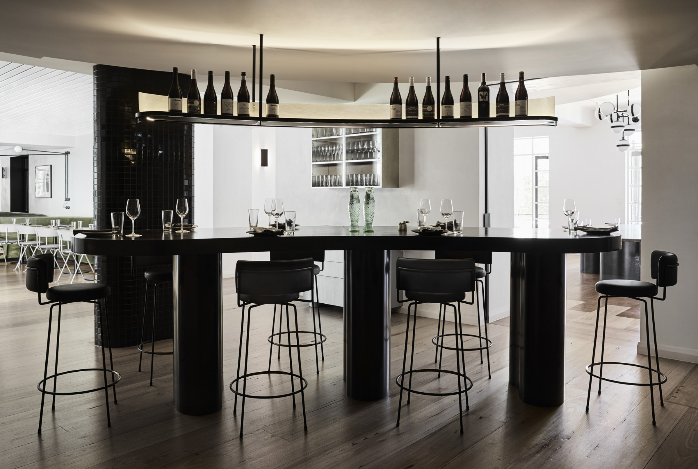 Modern dining room interior with bar stools and wine bottles from Prince Dining Room.