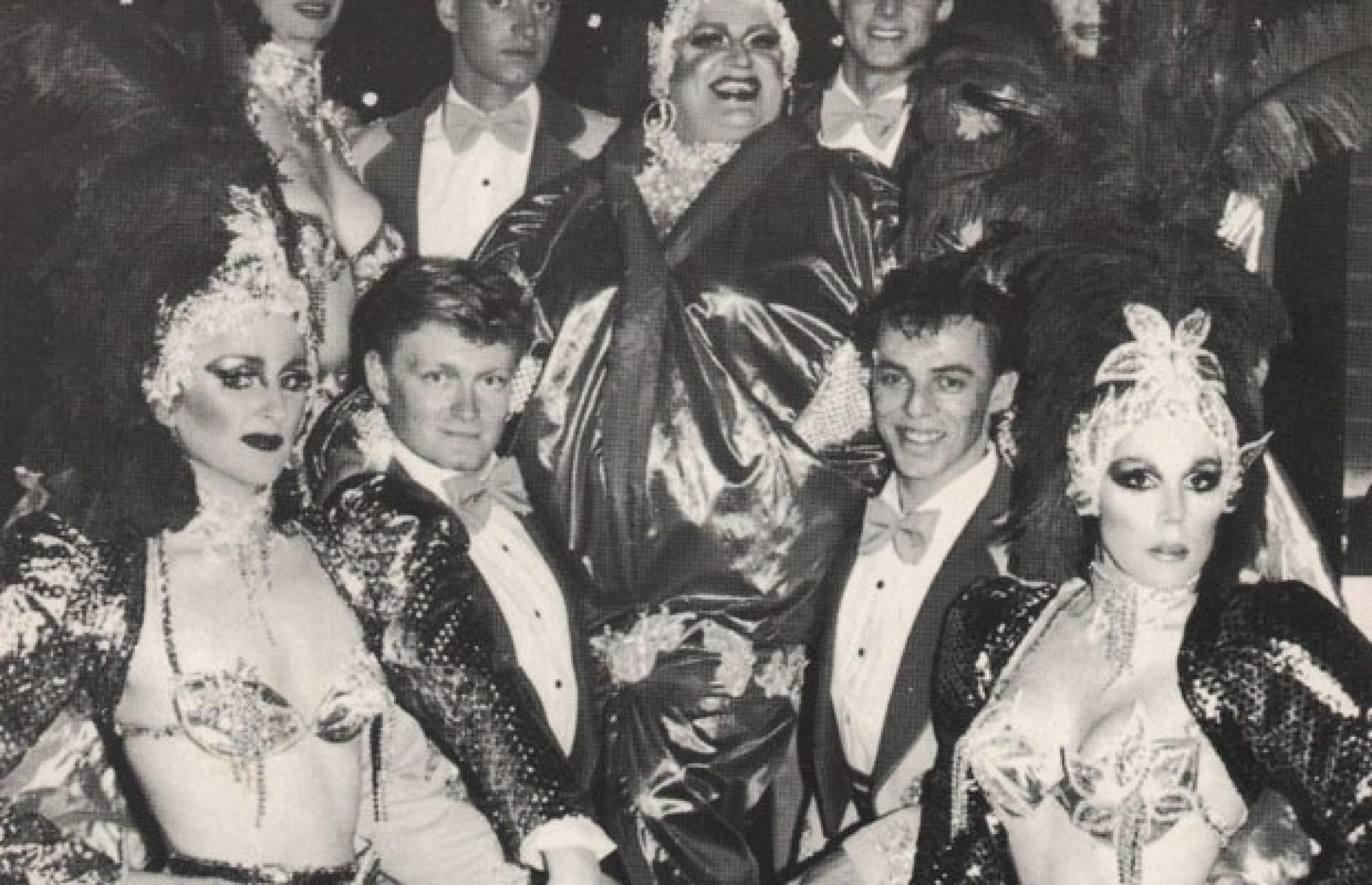 Performers in elaborate costumes pose for the Prince Dining Room project in a vintage black-and-white photo.