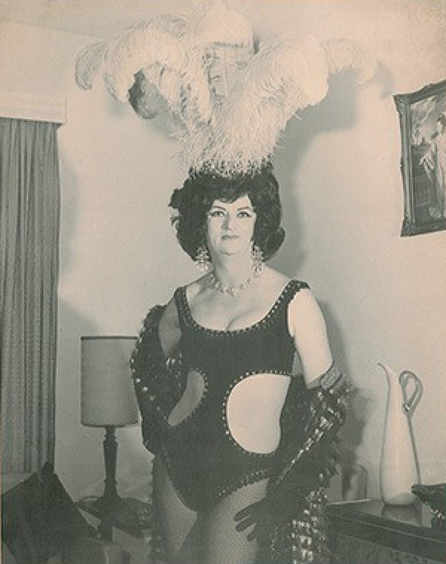 Person in elaborate costume with feathered headdress in Prince Dining Room setting.